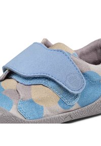 Zapato de velcro con un upper texturizado en azul, beige y patrones circulares en gris claro, con una suela gris flexible y un cuello acolchado.