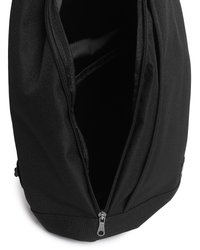 Črn nahrbtnik iz tkanine z odprtim glavnim zadrgo, ki razkriva prazen notranji predal in ojačane šive.