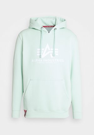 Hellmintgrüner Hoodie mit Fronttasche, Kordeln und weißem "Alpha Industries Knoxville, Tennessee, U.S.A."-Logo auf der Brust.