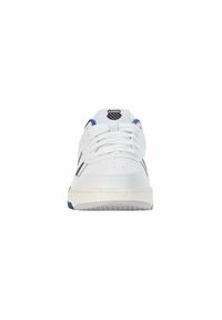 Scarpe atletiche bianche con tomaia in pelle liscia, punta rotonda, accenti blu, lacci piatti e logo sulla linguetta. Suola in gomma con grip testurizzato.