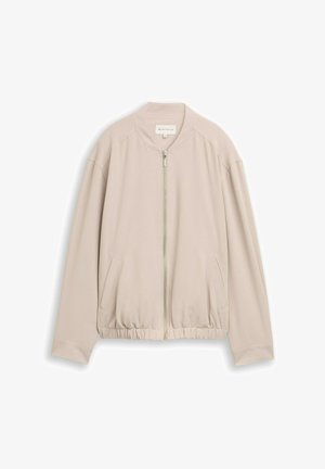 Beige bomberdzseki cipzárral az elején, bordás nyakkal, elasztikus derékrésszel és zsebekkel az oldalán. Simább, könnyű anyagból készült.