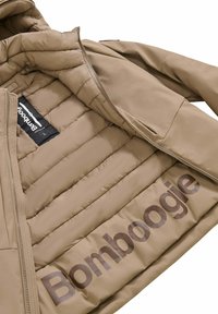 Tan pufferjacke met een gladde buitenkant, geborduurd patroon en het merk "Bomboogie" op de binnenvoering, met ritssluiting.