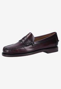 Mocasines de cuero marrón con costuras, diseño de mocasín, suela plana y tacón bajo. Textura suave sin herrajes o patrones visibles.