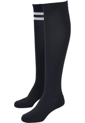 Chaussettes noires montantes en matériau doux, avec deux rayures blanches horizontales en haut. Texture lisse, design ajusté.
