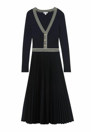 Melnas garām piedurknēm krokots vidēja garuma kleita ar V veida izgriezumu, baltām svītrainām apmalēm un trim zelta pogām priekšpusē uz krūšu daļas.