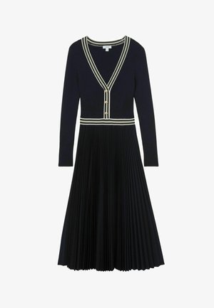 Melnas garām piedurknēm krokots vidēja garuma kleita ar V veida izgriezumu, baltām svītrainām apmalēm un trim zelta pogām priekšpusē uz krūšu daļas.