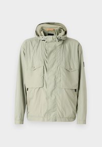 Light green lightweight jacket with a hood, two chest pockets, and side zippers. Features a smooth texture and adjustable drawstrings.