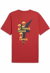 Camiseta de algodón roja con un gráfico en negro y amarillo que presenta el texto "Puma" y un diseño de estrella en la parte trasera. Manga corta y corte clásico.