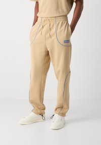 HUGO NIPIPEPANT - Pantalones deportivos - medium beige