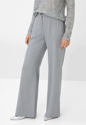 Pantaloni grigi a gamba larga in tessuto testurizzato, con una vestibilità su misura, tasche laterali e una cintura liscia, abbinati a scarpe argentate a punta.