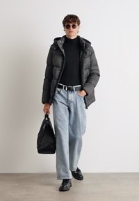 Musthave mustatud voodriga jakk, must kõrge kaelusega särk, laiad sinised teksad, mustad kingad, päikeseprillid ja must mustriga kott. Loodud silmapaistva kihtide süsteemiga sokk.
