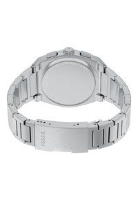 Zegarek ze stali nierdzewnej z polerowaną bransoletą, ośmiokątną kopertą i gładkim tyłem z wygrawerowanymi detalami. Regulowane zapięcie dla dopasowania rozmiaru.