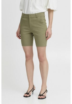 Olive green tailored shorts with side pockets, smooth texture, and a clean design. Paired with black strappy high-heeled sandals.