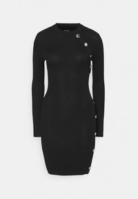 Černé šaty z žebrovaného úpletu s dlouhými rukávy, kulatým výstřihem a dekorativními stříbrnými knoflíky po straně, přiléhavý střih a délka ke kolenům.