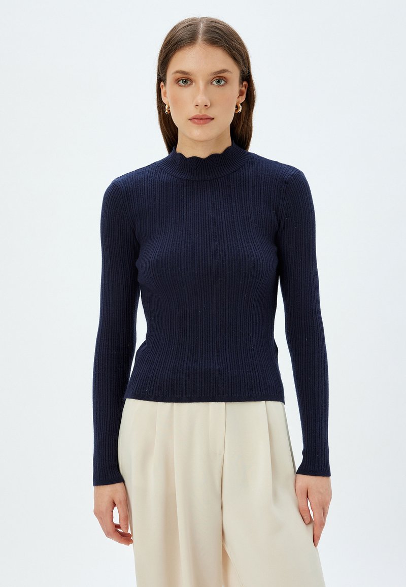 Marineblaues, geripptes Langarmshirt mit hohem Kragen, das einen gewellten Saum und eine taillierte Silhouette aufweist. Glatte Textur, minimalistisches Design.