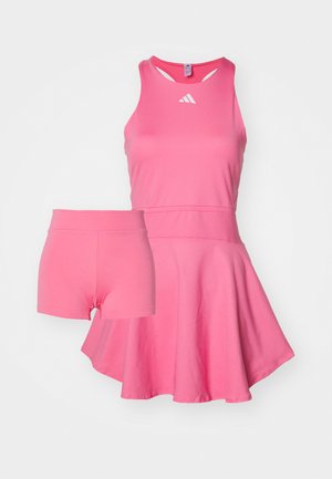 Light pink athletic dress with a flared skirt and matching pink shorts underneath. Made from smooth, stretchy fabric, featuring a round neckline.