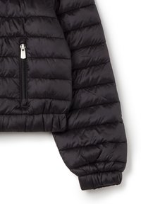 Giacca puffer nera con design cropped, che presenta imbottitura trapuntata, chiusura frontale con zip e polsini elasticizzati. Tessuto liscio e lucido.