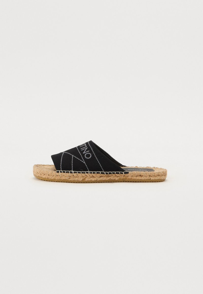 Espadrile negre din pânză, cu talpă din jute împletit, având un design cu bandă încrucișată și linii geometrice albe contrastante.
