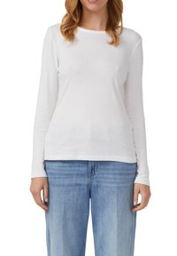 Witte lange mouwen shirt van zachte katoen. Eenvoudig ontwerp met een ronde halslijn, strakke mouwen en een rechte zoom. Draag het met lichtblauwe jeans.
