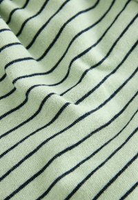 Tissu vert clair avec des rayures horizontales bleu marine, présentant une texture douce et un léger stretch, mettant en valeur le motif tricoté.