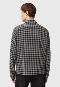 Zwart-witte geruite blouse, met knoopsluiting, een gespreide kraag en lange mouwen. Gemaakt van geweven stof met een gestructureerde afwerking en knoopmanchetten.