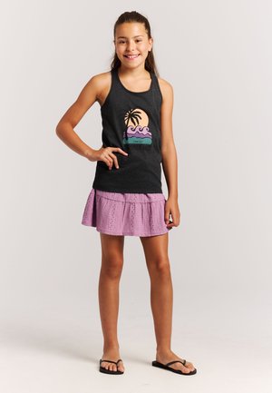 Grijs tanktop met een afbeelding van een zonsondergang en een palmboom, gecombineerd met een lichtpaarse rok met kanten details. Zwarte slippers.