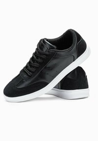 Sneaker nere con una parte superior in pelle liscia e dettagli in suede, dotate di suola in gomma bianca, chiusura con lacci e dettagli perforati sui lati.