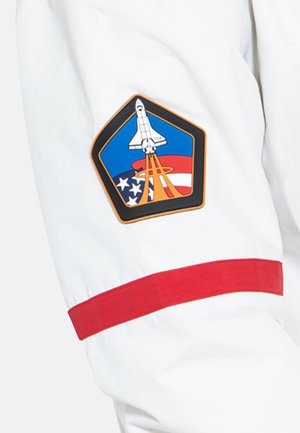 Weiße Jacke mit rotem Bündchen und einem bestickten Aufnäher mit einem Space Shuttle, amerikanischen Flaggen und kreisförmigen Akzenten in Blau und Rot.
