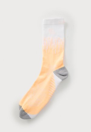 Light orange and white socks with a gradient design; gray heel and toe accents; textured fabric with diagonal stripes and patterns.