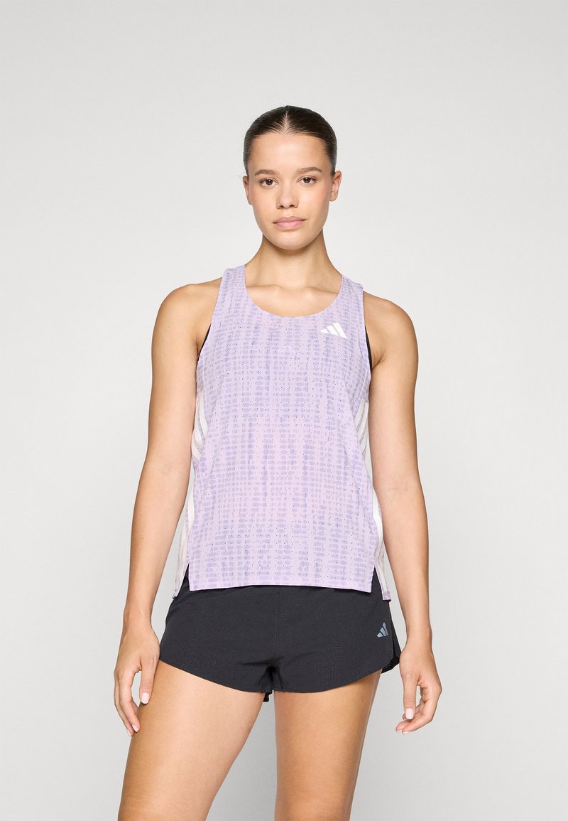 Lichtpaarse tanktop met een textuurpatroon, ronde halslijn en zijsplitten, gecombineerd met zwarte shorts. Bevat witte logo-accenten.