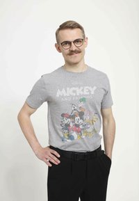 Camiseta de manga corta gris con un gráfico colorido de personajes de dibujos animados: Mickey Mouse, Donald Duck, Goofy, Daisy Duck y Pluto.