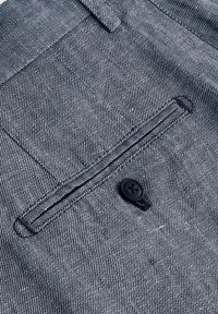 Tissu rayé bleu et blanc avec un détail de poche, comprenant un bouton noir et une couture contrastante. Texture lisse et design ajusté.