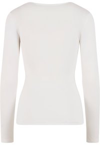 Ilgomis rankovėmis prigludęs viršus iš minkštos baltos medžiagos. Paprastas apvalus kaklo iškirpimas ir lygi tekstūra be matomų raštų ar papuošimų.