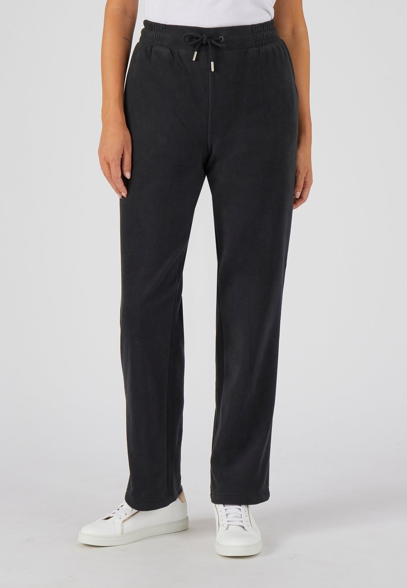 Zwarte fleece joggers met een elastische tailleband en trekkoord, voorzien van zijzakken en een recht pijpdesign. G gedragen met witte sneakers.