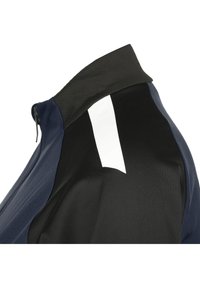Giacca da ciclismo da uomo con un design nero e blu navy, corpo testurizzato e una striscia riflettente bianca sul retro per una maggiore visibilità.