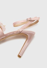 Pink satin high-heeled sandal with an ankle strap, silver buckle, and decorative pearl accents on the upper. Pointed toe and sleek silhouette.