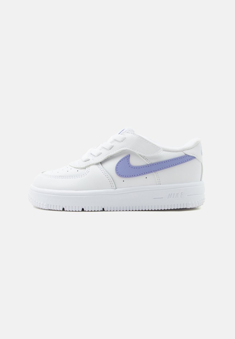 Baskets basses blanches Nike avec logo swoosh violet clair, fermeture à lacets et semelle texturée, vues du côté extérieur sur fond uni.
