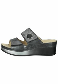 Black slip-on wedge sandal with an open toe, featuring a textured strap with a circular accent and a smooth, shiny finish.