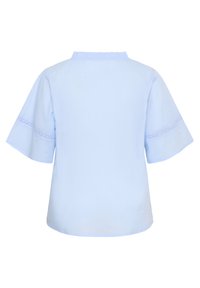 Blouse bleu clair à manches courtes avec col à volants et détails en dentelle autour des manches, vue de dos sur un fond uni.