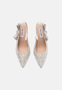 Kiiltävät kärkitossut beige satiinista, koristeltu hopeisilla paljeteilla ja yhdistetty suuri beige nauha kantapäässä. Merkki: Steve Madden.