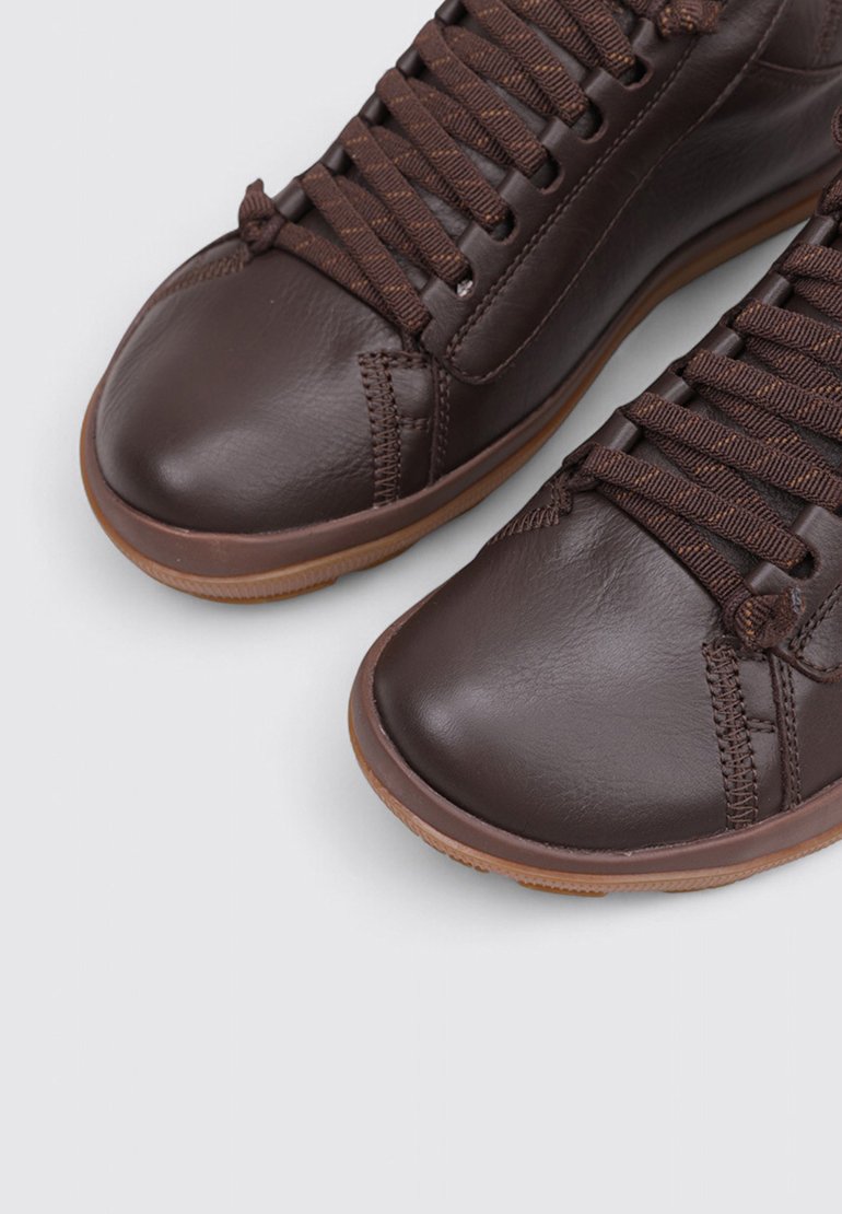 Brune lædersneakers med runde tåspidser, teksturerede snørebånd og gummisål. Har diskrete syninger og en glat overflade.