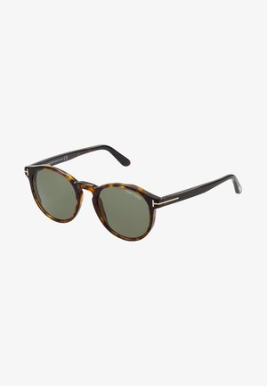 Gafas de sol redondas de carey con lentes verdes. Accentos de metal en las patillas y distintivo logo "T". Patillas anchas.