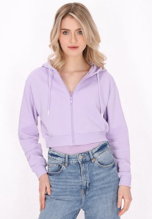 Cropped zip-up hoodie in light purple, featuring a drawstring hood and ribbed cuffs, paired with high-waisted blue jeans.