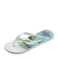 Tongs blanches avec semelle texturée et brides blanches, présentant un imprimé de plage et d'océan sur la semelle intérieure et le logo "Havaianas" sur la bride.