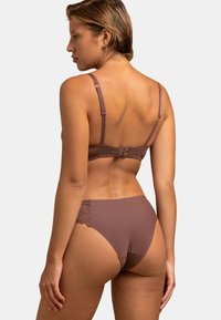 Ensemble de lingerie marron avec une finition en tissu lisse, des bretelles réglables et des accents en dentelle au dos des culottes. Vue de dos affichée.