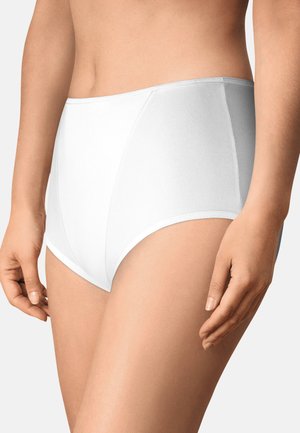 Mujer con bragas blancas de talle alto, mostrando torso y parte superior de las piernas sobre un fondo claro y liso.