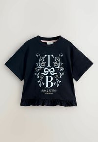 T-shirt en coton bleu marine avec des motifs floraux blancs et un monogramme, manches courtes et un ourlet à volants pour plus de détails.