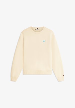 Sweat-shirt couleur crème avec un col rond côtelé, des manches longues et un logo frontal en bleu clair. Présente un ourlet droit et une texture subtile.
