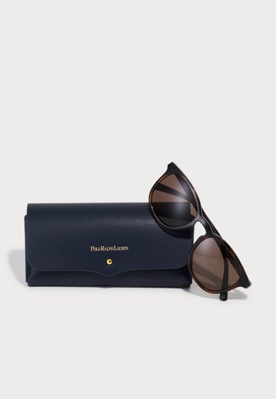 Ochelari de soare Polo Ralph Lauren cu lentile maro, rame elegante din testă de broască țestoasă și etui protector albastru cu un logo auriu și închidere tip snap.