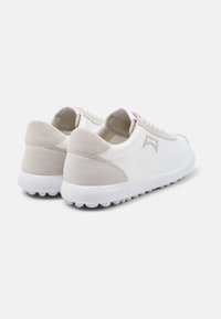 White sneakers with grey suede accents, a smooth texture, round toe, and white rubber sole featuring small circular grips.